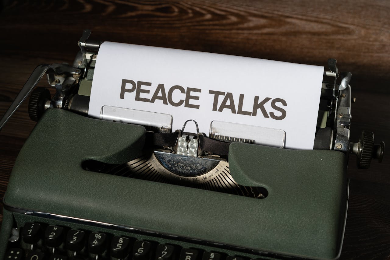A classic typewriter displays the words 'Peace Talks', symbolizing communication and diplomacy.